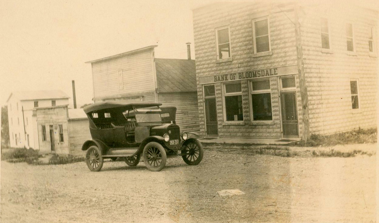 old photo of Model T in front of Bank of Bloomsdale